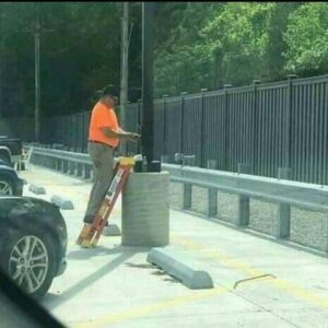 Man in orange shirt works while standing on a very short ladder, New York Labor Law claim waiting to happen